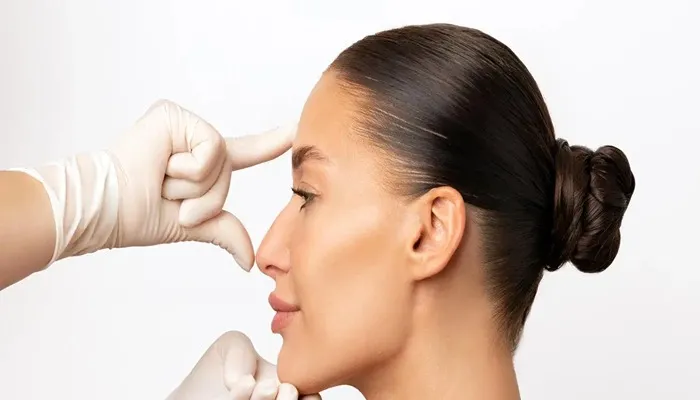 معاینه نیم‌رخ بینی استخوانی توسط جراح زن در محیط کلینیک